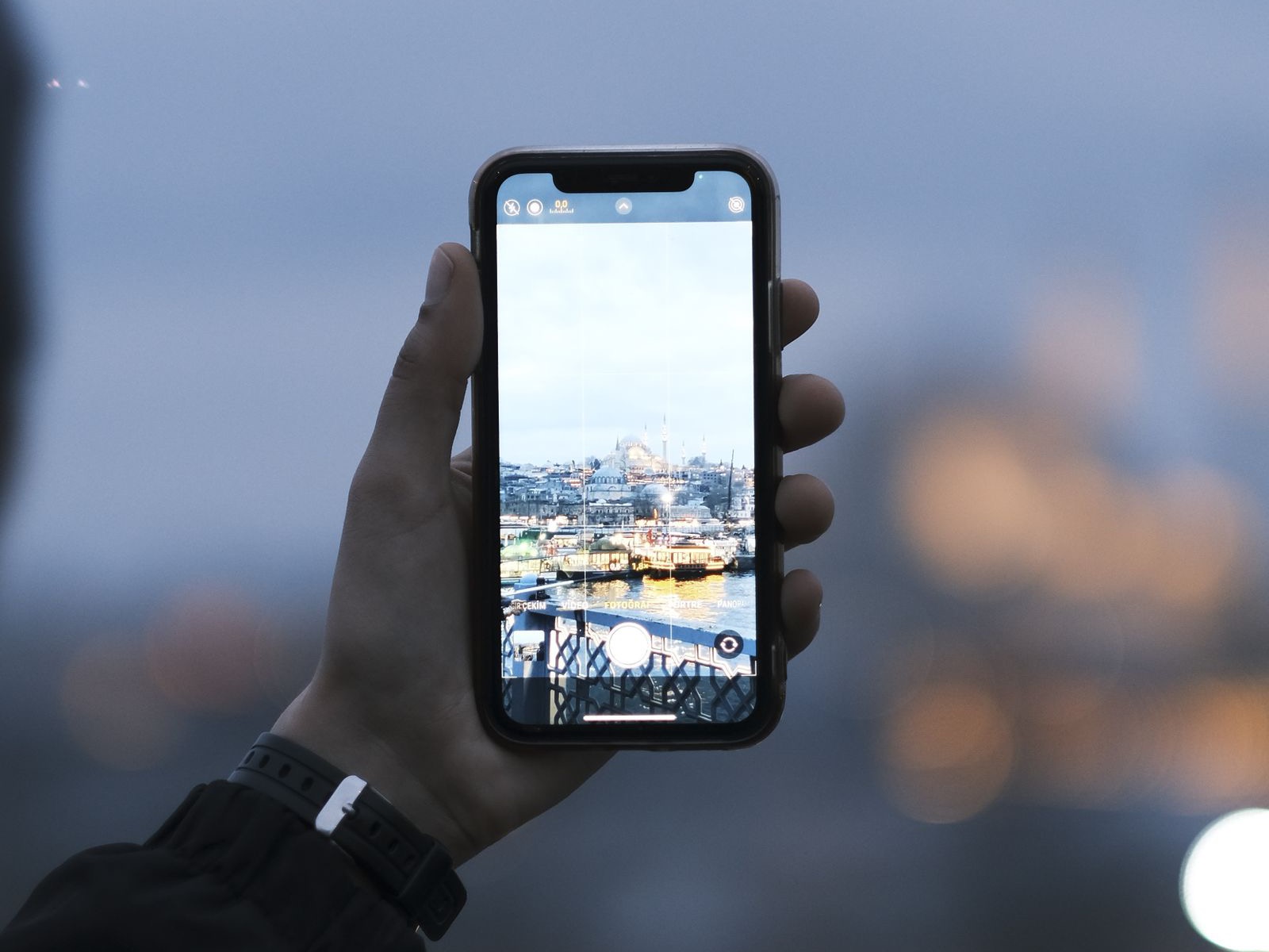 A hand holding a phone mid-shot, the short-form filming Instagram Reels post-view ads now run behind.