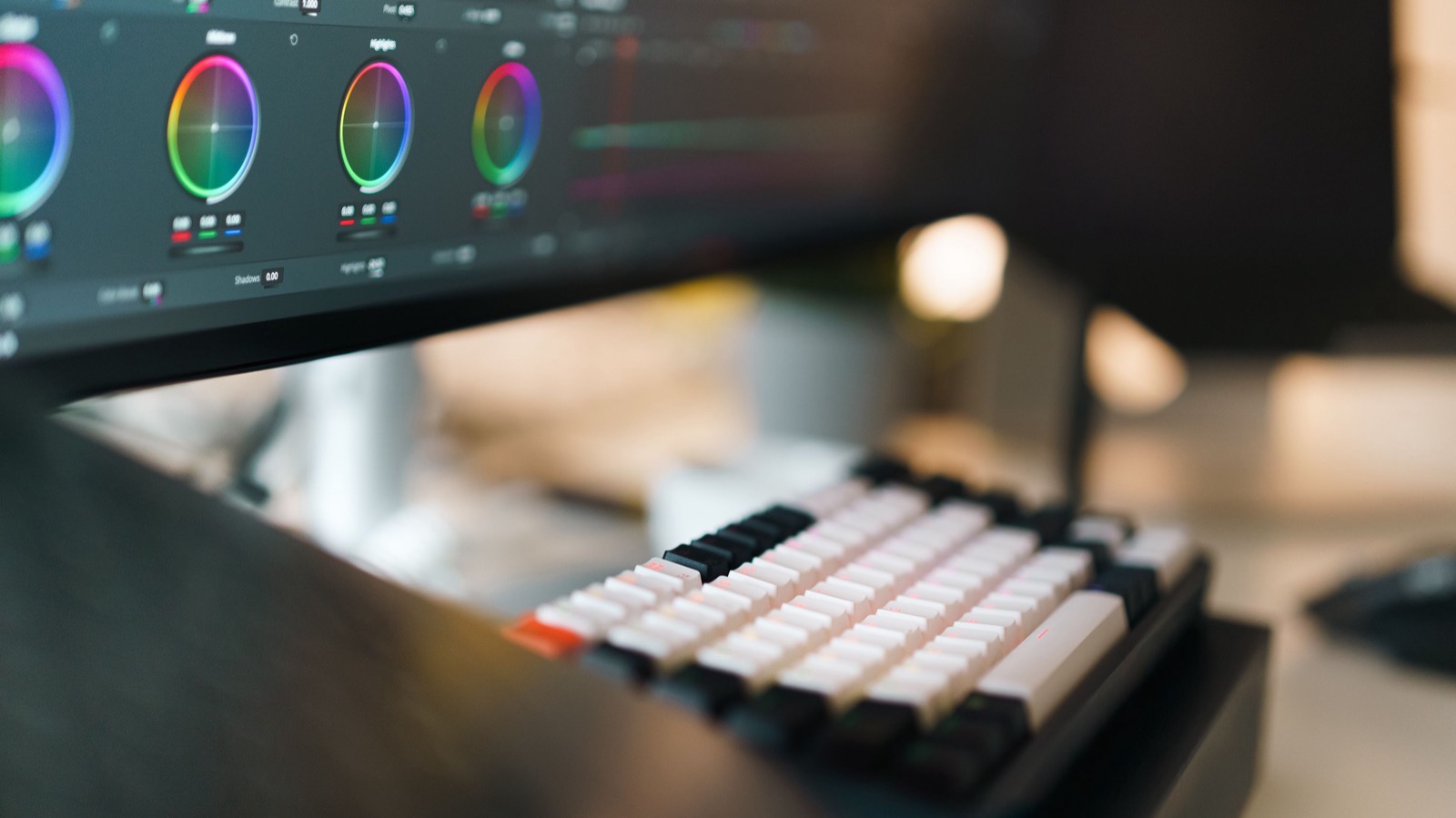 A color-grading monitor and keyboard on a video editing desk, the hands-on review PMax AI video resizing skips.